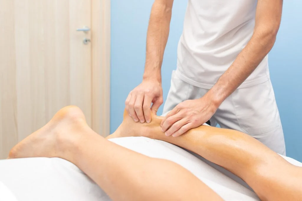 Healthcare professional examining a patient's Achilles tendon.