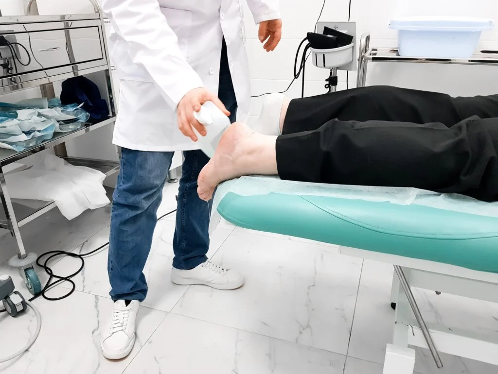 Doctor performing shockwave therapy on a patient
